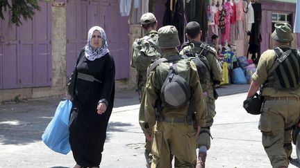 Des militaires de l'arm&eacute;e isra&eacute;lienne patrouillent dans le march&eacute; de la vieille ville d'H&eacute;bron, en Cisjordanie, le 13 ao&ucirc;t 2014. (MAXPPP)