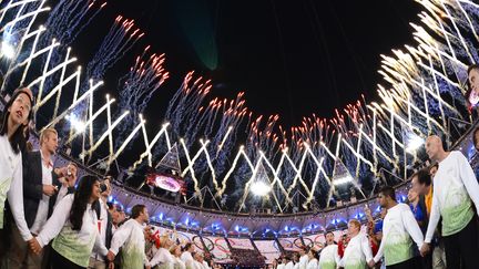 Les volontaires forment une haie d'honneur pour l'entr&eacute;e des athl&egrave;tes dans le stade. (LEON NEAL / AFP)