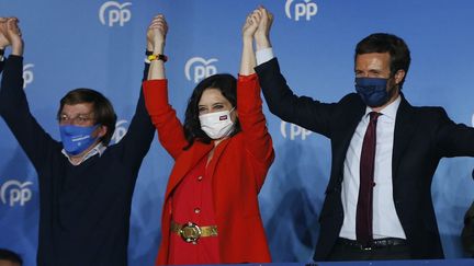 Madrid, le 4 mai 2021. Isabel Diaz Ayuso, au centre, la candidate du Parti Populaire, victorieuse aux élections régionales du 4 mai, Pablo Casado, le leader du PP, à droite, et le maire de Madrid, Jose Luis Martinez Almeida, à gauche.&nbsp; (SENHAN BOLELLI / ANADOLU AGENCY / AFP)