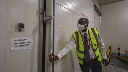 Peter Musola, responsable du fret à l'aéroport international de Nairobi (Kenya), le 11 février 2021 devant la chambre froide où les doses de vaccins pourraient être stockées. (TONY KARUMBA / AFP)