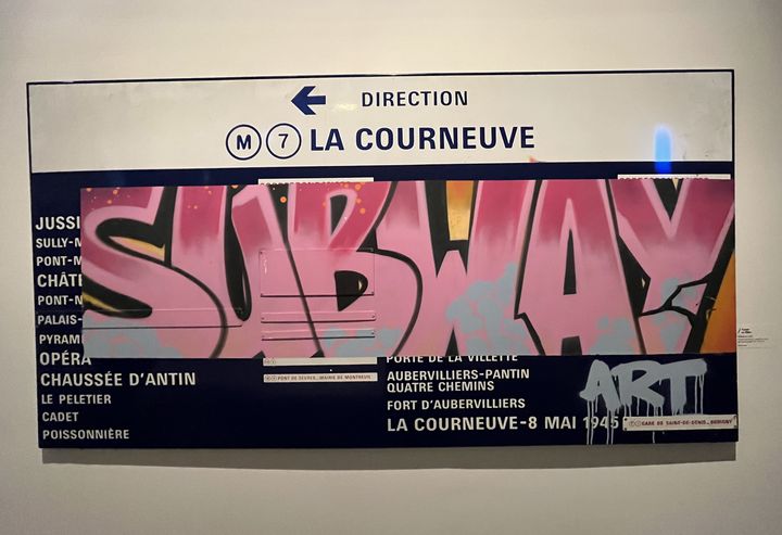 Un panneau de ligne de métro "décoré" d'un "Subway Art" au lettrage à l'ancienne, référence au nom d'un livre mythique paru en 1984 sur le graffiti new-yorkais,&nbsp;qui a énormément inspiré les artistes&nbsp;français. (LAURE NARLIAN / FRANCEINFO CULTURE)