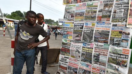 Les unes de la presse ivoirienne, dans les rues d'Abidjan (Côte d'Ivoire), le 14 mars 2016, au lendemain de l'attaque de&nbsp;Grand-Bassam.&nbsp; (SIA-KAMBOU / AFP)