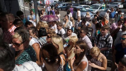 Des familles de vacanciers bloqu&eacute;s attendent devant le si&egrave;ge du tour op&eacute;rateur en faillite&nbsp;Labyrinth, lundi 4 ao&ucirc;t 2014. (VLADIMIR PESNYA / RIA NOVOSTI / AFP)