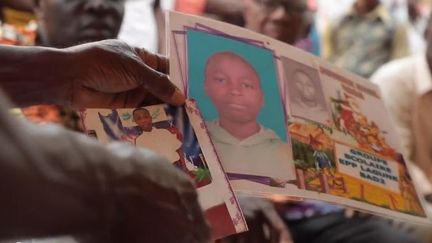 Des proches du jeune garçon ivoirien mort dans le train d'atterrissage d'un avion, à Paris, montre des photos de l'adolescent, en janvier 2020.&nbsp; (FRANCE TELEVISIONS)