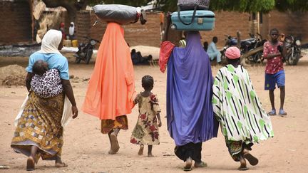 Des civils quittent le village de Kukawa dans l'Etat du Plateau (centre du Nigeria) le 12 avril 2022, après que leurs maisons ont été incendiées lors d'une attaque par des hommes armés. (AFP)