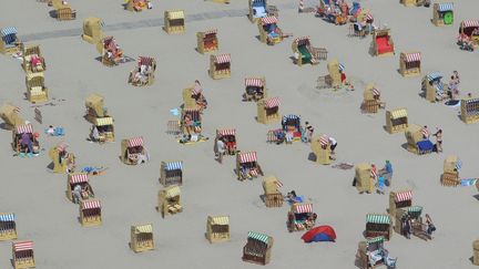 Des touristes prennent le soleil, assis dans leurs chaises de plage &agrave; Travem&uuml;nde, dans le nord de l'Allemagne, le 23 juillet 2012. (MARKUS SCHOLZ / DPA / AFP)