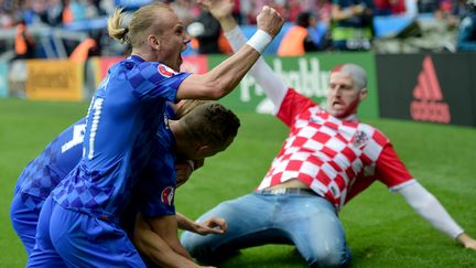 Un supporter de la Croatie se jette à genoux en direction des joueurs, dimanche 12 juin au parc des Princes, après le but de Luka Modric contre la Turquie.&nbsp; (BULENT KILIC / AFP)