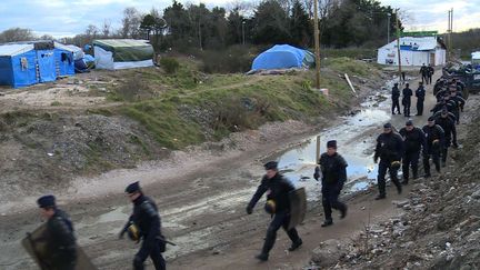 En début de matinée, de nombreux policiers sont intervenus pour quadriller la zone évacuée. Une trentaine de véhicules de CRS et deux camions antiémeutes ont été stationnés à l'entrée ouest du camp. (CHRIS DEN HOND/AP/SIPA)