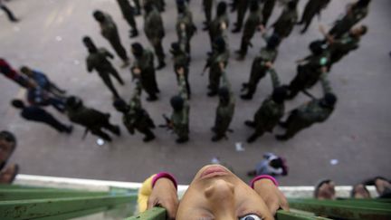 Une jeune Palestinienne regarde d&eacute;filer depuis son balcon des membres du Hamas &agrave; Rafah (Palestine), le 13 novembre 2014. ( IBRAHEEM ABU MUSTAFA / REUTERS)