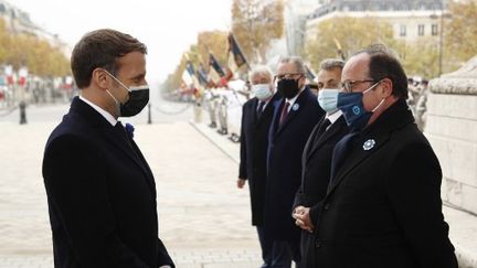 Emmanuel Macron et François Hollande, le 11 novembre 2020, sous l'Arc de Triomphe, à Paris. (YOAN VALAT / POOL)