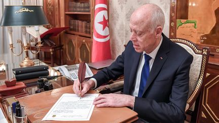 Le chef de l'Etat tunisien, Kaïs Saïed, en train d'écrire une lettre dans son bureau au palais présidentiel de Carthage, le 19 février 2020.&nbsp; (AFP - TUNISIAN PRESIDENCY)