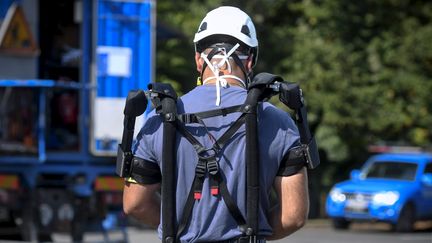 Un technicien d'Enedis équipé d'un exosquelette, à Toulouse (Haute-Garonne) le 21 juillet 2020 (XAVIER DE FENOYL / MAXPPP)