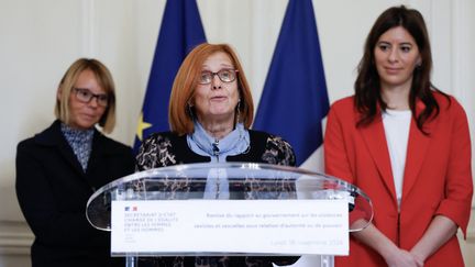 La haute fonctionnaire Christine Abrossimov prononce un discours à l'occasion de la remise du rapport, aux côtés de la gynécologue Marie-France Olieric (G) et de l'avocate Rachel-Flore Pardo (D), le 18 novembre 2024 à Paris. (IAN LANGSDON / AFP)