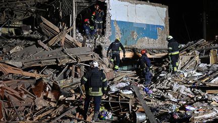 Les sauveteurs du Service d'urgence de l'État inspectent les restes d'un immeuble à Kharkiv (Ukraine), le 1er novembre 2024. (SERGEY BOBOK / AFP)