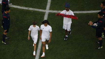 São Paulo (Brésil), le 12 juin 2014. Cérémonie d'ouverture de la Coupe du Monde de football. Jeune Indien guarani arborant une bannière de protestation.

	  (REUTERS/Fabrizio Bensch )