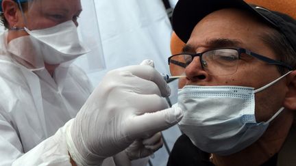 Un homme subit un prélèvement nasal dans un centre de dépistage du Covid-19, à Laval (Mayenne), le 9 juillet 2020. (JEAN-FRANCOIS MONIER / AFP)