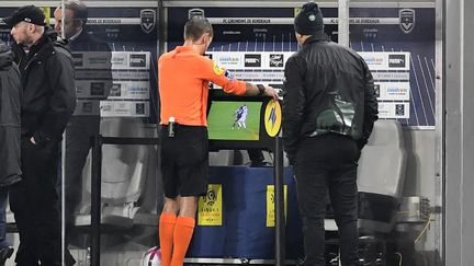 L'arbitre français Clément Turpin vérifie une action litigieuse grâce à la VAR lors de la rencontre de Ligue 1 Bordeaux-Saint-Etienne, le 5 décembre 2018, à Bordeaux. (NICOLAS TUCAT / AFP)