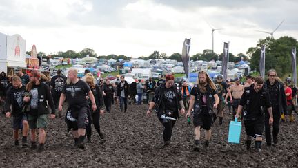 Le festival de métal de Wacken s'est ouvert sous une pluie torrentielle, forçant les participants à revêtir bottes en caoutchouc et vêtements imperméables. (CHRISTIAN CHARISIUS / DPA via AFP)