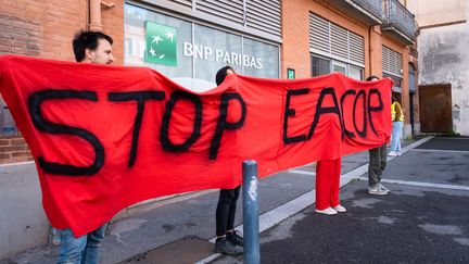 Des militants affichent leur opposition au projet pétrolier EACop de TotalEnergies, à Toulouse, le 10 mai 2023. (ADRIEN NOWAK / HANS LUCAS / AFP)