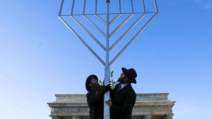 Deux rabbins installent un menorah g&eacute;ant devant la porte de Brandebourg &agrave; l'occasion des c&eacute;l&eacute;brations d'Hanouka &agrave; Berlin (Allemagne), le 7 d&eacute;cembre 2014. (MARKUS SCHREIBER / AP / SIPA)