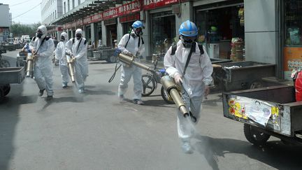 Une équipe de volontaires désinfecte lesallées du marché de Yuegzzhuang après plusieurs nouvelles infections au Covid-19, à Pékin en Chine le 16 juin 2020. (CHINA DAILY CDIC / REUTERS)