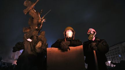 Des manifestants se tiennent sur des barricades, place de l'Ind&eacute;pendance &agrave; Kiev (Ukraine), mercredi 19 f&eacute;vrier. (LOUISA GOULIAMAKI / AFP)