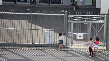 Des enfants arrêtés devant la grille de leur école, à Nantes, le 22 avril 2020. Photo d'illustration. (ROMAIN BOULANGER / MAXPPP)