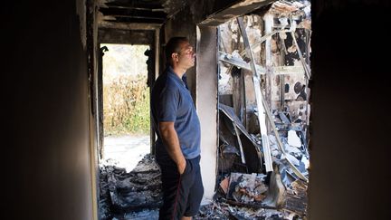 Un homme constate les dégâts des feux de forêt dans sa maison, aux Pennes-Mirabeau (Bouches-du-Rhône), le 11 août 2016. (MAXPPP)