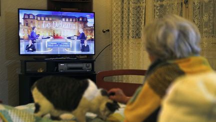 Une téléspéctatrice devant sa télévision, regarde le débat entre Emmanuel Macron et Marine Le Pen, mercredi 20 avril. (PASCAL POCHARD-CASABIANCA / AFP)