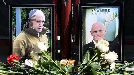 Des fleurs sont déposées devant des photos d'Evguéni Prigojine et Dmitri Outkine à Novosibirsk (Russie), le 24 août 2023, au lendemain du crash de leur avion privé près de Moscou. (VLADIMIR NIKOLAYEV / AFP)