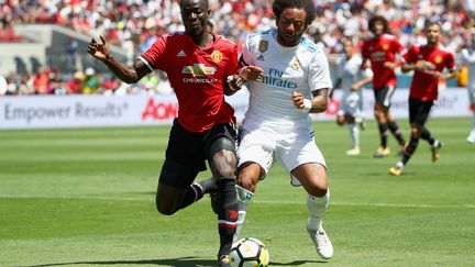 Le défenseur ivoirien de Manchester United, Eric Bailly (en rouge, à gauche), à la lutte avec le latéral brésilien du Real Madrid, Marcelo (en blanc, à droite). (EZRA SHAW / GETTY IMAGES NORTH AMERICA)