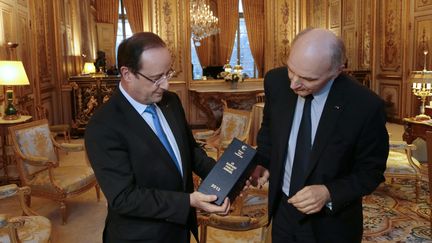 Fran&ccedil;ois Hollande re&ccedil;oit un rapport de la Cour des comptes des mains de son pr&eacute;sident, Didier Migaud, le 11 f&eacute;vrier 2012 &agrave; l'Elys&eacute;e (Paris). (JACQUES DEMARTHON / AFP)