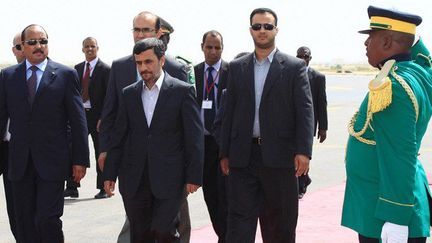 Le président mauritanien Mohamed Ould Abdel Aziz (à gauche) accueille son homologue iranien de l'époque, Mahmoud Ahmadinejad (au centre), le 25 septembre 2011 à l'aéroport de Nouakchott.  (MAURITANIA NEWS AGENCY/AFP)