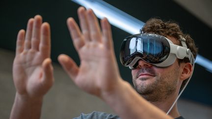 Un client teste les nouvelles lunettes d'ordinateur Vision Pro dans un Apple Store, à Berlin, le 12 juillet 2024. (MONIKA SKOLIMOWSKA / DPA)