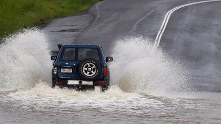 Un 4 X4 sur une route inondée à Rocklea, à l'ouest de Brisbane, le 10 janvier 2011. (AFP)