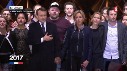 Morgan Simon, au centre avec la casquette, chante la "Marseillaise" avec Emmanuel Macron, devant la pyramide du Louvre, à Paris, le 7 mai 2017. (FRANCE 2)