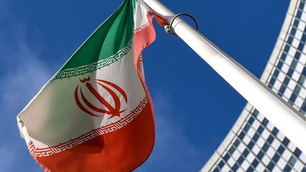 Le drapeau iranien&nbsp;flotte devant le siège de l'Agence internationale de l'énergie atomique, le 1er mars 2021 à Vienne (Autriche). (JOE KLAMAR / AFP)