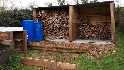 Dans le Morbihan, Thierry Brulavoine, porte-parole de La Maison commune de la décroissance, coupe lui-même son bois et récupère l'eau de pluie. (BENJAMIN MATHIEU / FRANCEINFO)