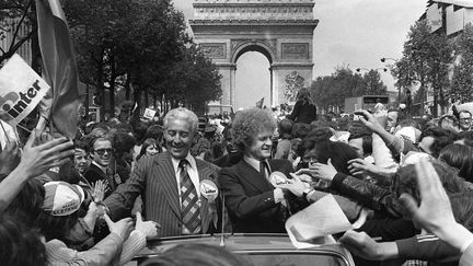 Le président du club de Saint-Etienne Roger Rocher et l'entraineur de l'équipe première Robert Herbin signent des autographes sur les Champs-Elysées, le 13 mai 1975. (STF / AFP)