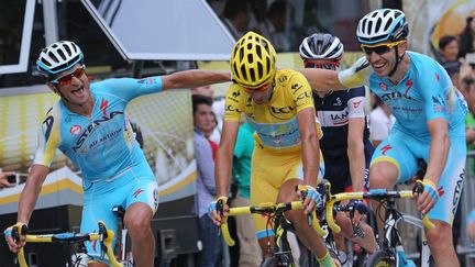 Vincenzo Nibali, entouré par deux membres de son équipe, lors de sa victoire au Tour de France 2014 pour l'équipe Astana. (DAVID SILPA / MAXPPP)