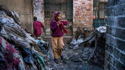 vit en Afrique du Sud,  où il a réalisé ce reportage «Les Otages du centre-ville de Johannesburg». «Pendant que le monde entier a les yeux rivés sur les migrants africains qui se déplacent vers le Nord pour atteindre les rivages européens, les milliers de migrants africains qui font route vers le Sud pour s’installer à Johannesburg, une des villes les plus riches d’Afrique, passent inaperçus. Certains ont trouvé refuge dans des bâtiments abandonnés du centre-ville, un quartier tristement célèbre pour son taux de criminalité, de pauvreté et de chômage», raconte le photographe.
 (Jonathan Torgovnik / The Verbatim Agency)