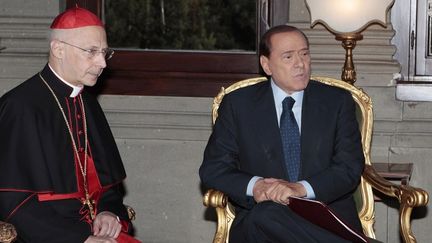 Angelo Bagnasco, le chef des &eacute;v&ecirc;ques italiens (&agrave; gauche) et Silvio Berlusconi (&agrave; droite), le 18 f&eacute;vrier 2011 &agrave; Rome. (GREGORIO BORGIA / AFP)