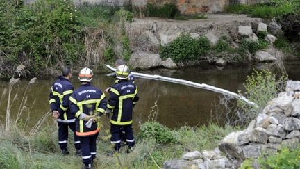 Des pompiers surveillent un barrage flottant installé sur la rivière le Largue, le 2 mai 2010 (AFP Photos)