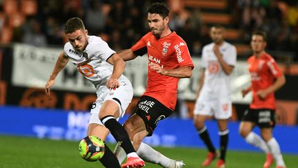 Le Lorientais Thomas Monconduit face au Lillois Johan Gudmundsson, vendredi à Lorient. (FRED TANNEAU / AFP)