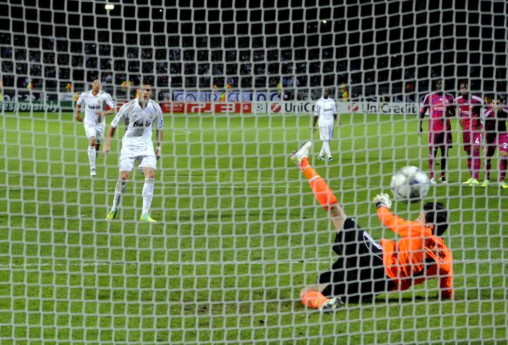 Cristiano Ronaldo (en blanc) transforme le penalty face &agrave; Hugo Lloris (en orange). Le match de poule de la Ligue des Champions se termine par un 2-0 pour le Real face &agrave; Lyon, le 2 novembre 2011. (Jean-Philippe Ksiazek / AFP)