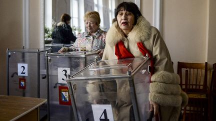 Des employ&eacute;s installent un bureau de vote pour le r&eacute;f&eacute;rendum du 16 mars 2014, en Crim&eacute;e. (VALERIY MELNIKOV / RIA NOVOSTI / AFP)