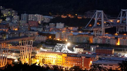 Les décombres du pont Morandi, éclairés pour permettre le travail des sauveteurs, dans la soirée du 14 août 2018 à Gênes (Italie). (STEFANO RELLANDINI / REUTERS)