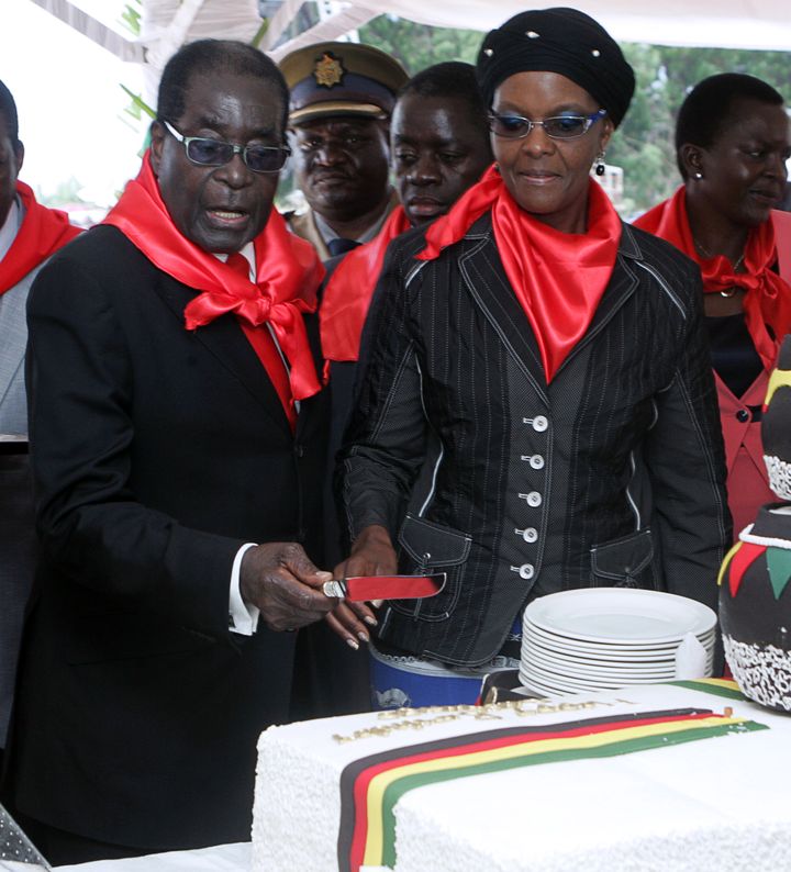 Robert Mugabe coupe son g&acirc;teau d'anniversaire pour ses 90 ans, aux c&ocirc;t&eacute;s de sa femme, le 23 f&eacute;vrier 2014 &agrave; Marondera (Zimbabwe). (JEKESAI NJIKIZANA / AFP)