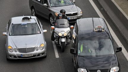 Moto-taxi encerclé par des voitures-taxi, 2009 (AFP. L.Bonaventure)