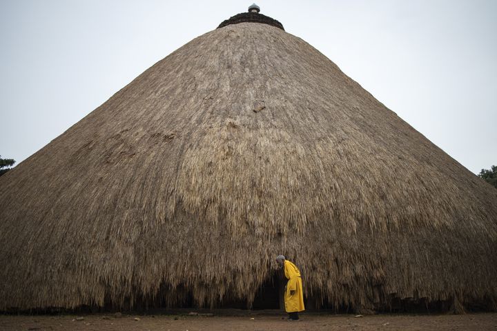 Un garde se tient devant l'un des bâtiments appartenant aux tombeaux royaux de Kasubi à Kampala, en Ouganda, le 13 juin 2023. (STUART TIBAWESWA / AFP)